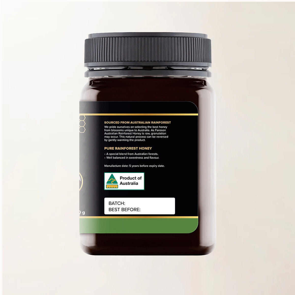 Jar of honey with a black lid on a beige background